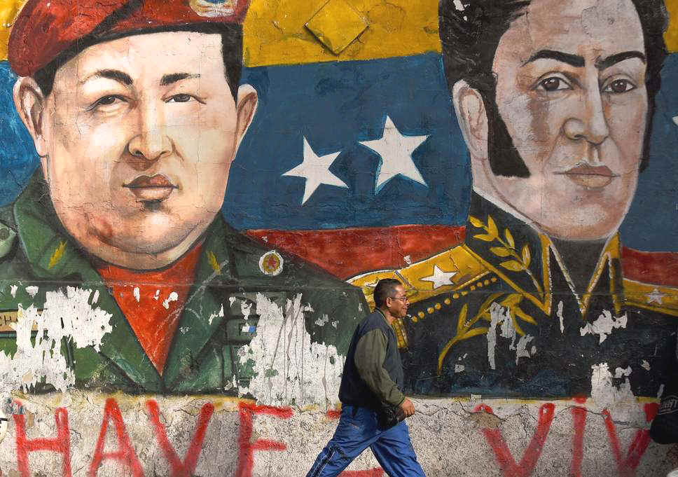 Hugo Chavez, on the left in this Caracas mural, died in 2013. The boom years of his populist presidency now seem a long-distant memory