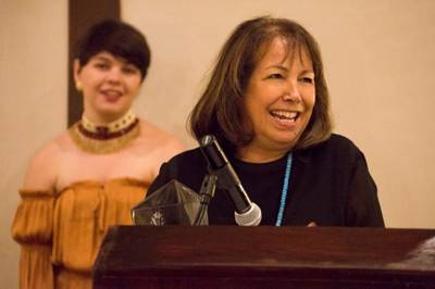 Vicki Vasques accepts the Native American Alumni Recognition Award at the Native American Heritage Month reception on Nov. 8 at the Fullerton Marriott. Raven Bennett-Burns, president of the Inter-Tribal Student Council, stands in the background. (Photo courtesy of Cal State Fullerton)